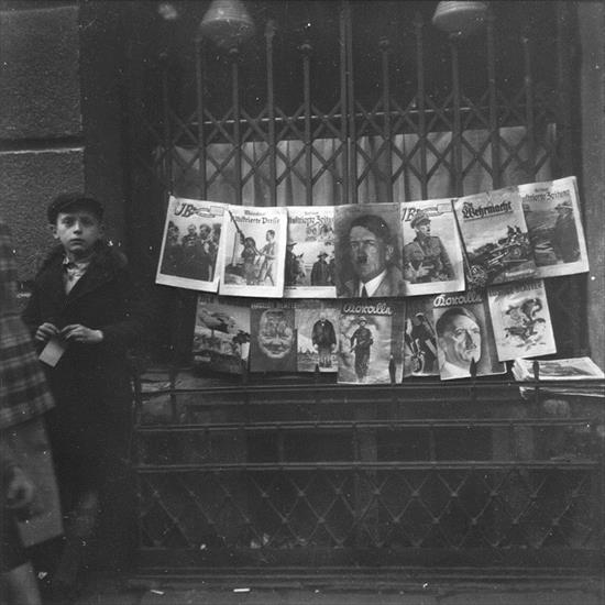 archiwalne fotografie II wojna światowa - A young boy sells German Nazi periodicals on a street in the Warsaw ghetto.jpg